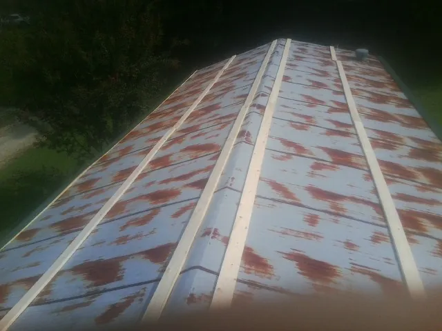 Rusted metal roof panels with new wood purlins before replacement — Storm Damage Roof Repair in Allgood by Roofing Brothers