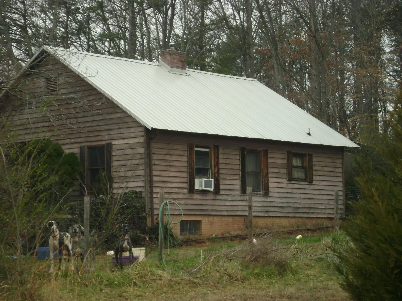 White metal roof on an old wood sided farmhouse, from a Metal Roof Installation job in Allgood